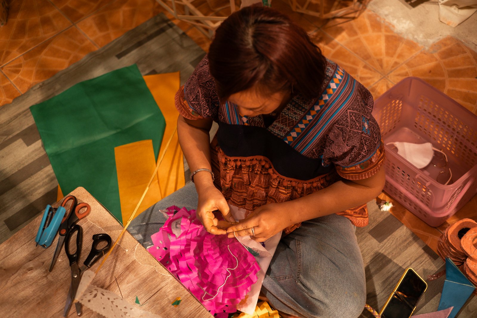 Hands crafting pink fabric flowers