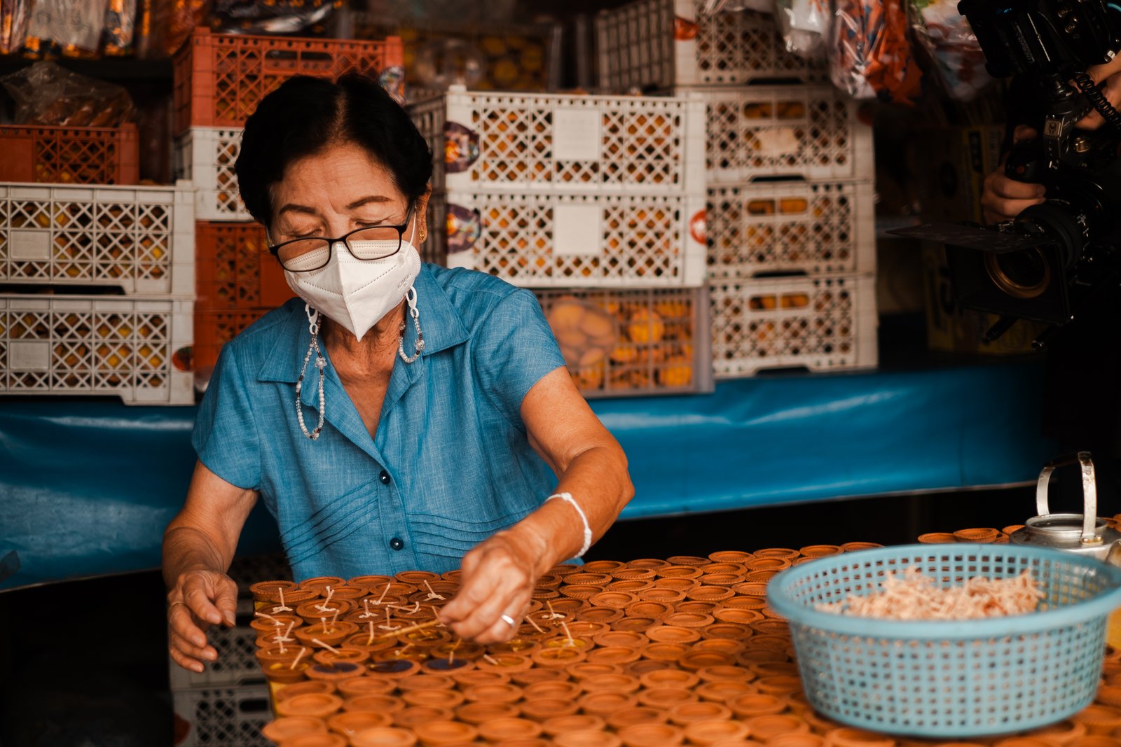 A craftswoman at her workshop table, wide scene in warm light
