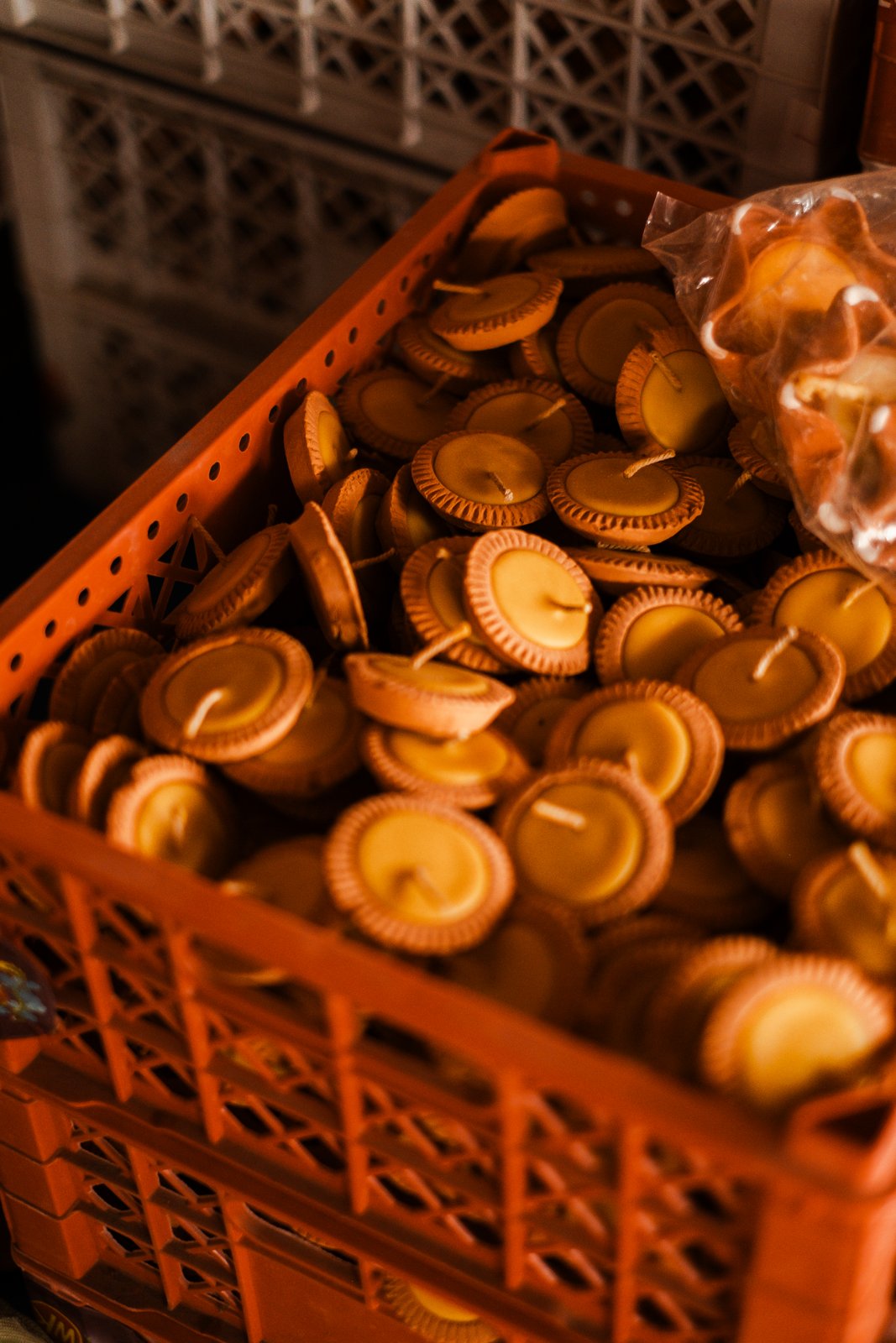 A crate filled with finished amber wax candles
