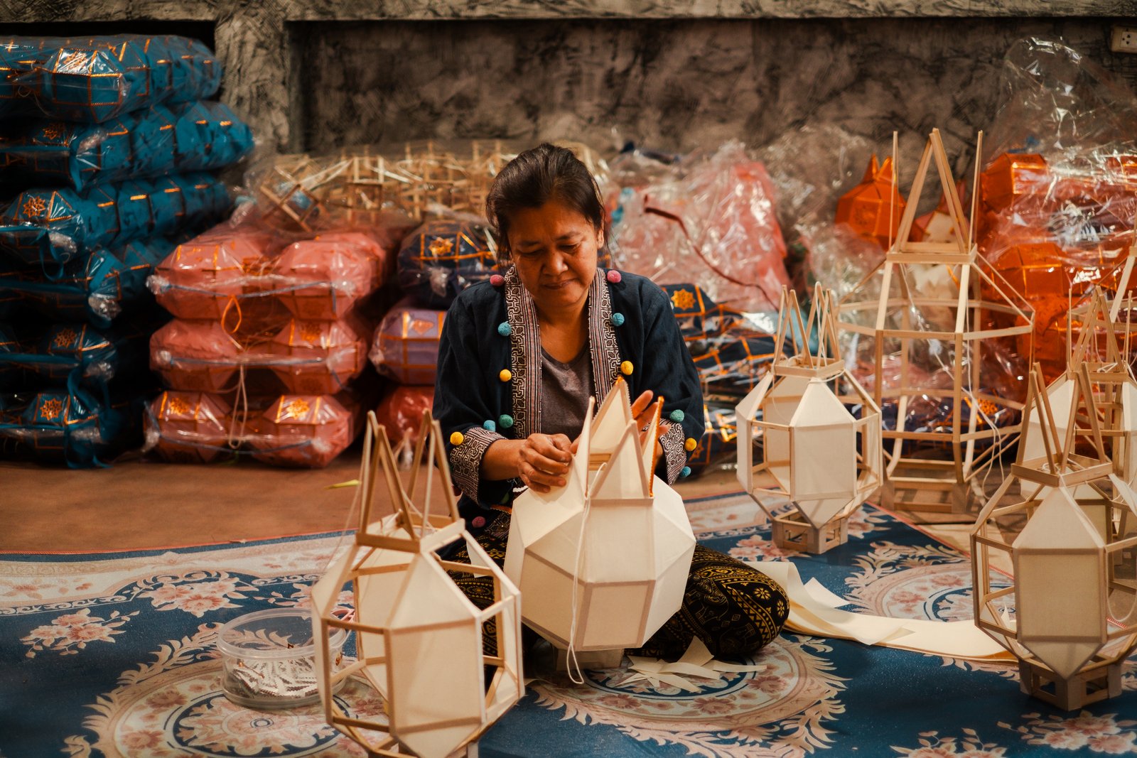 Lantern assembly in the workshop, a wall of colorful yarn balls behind