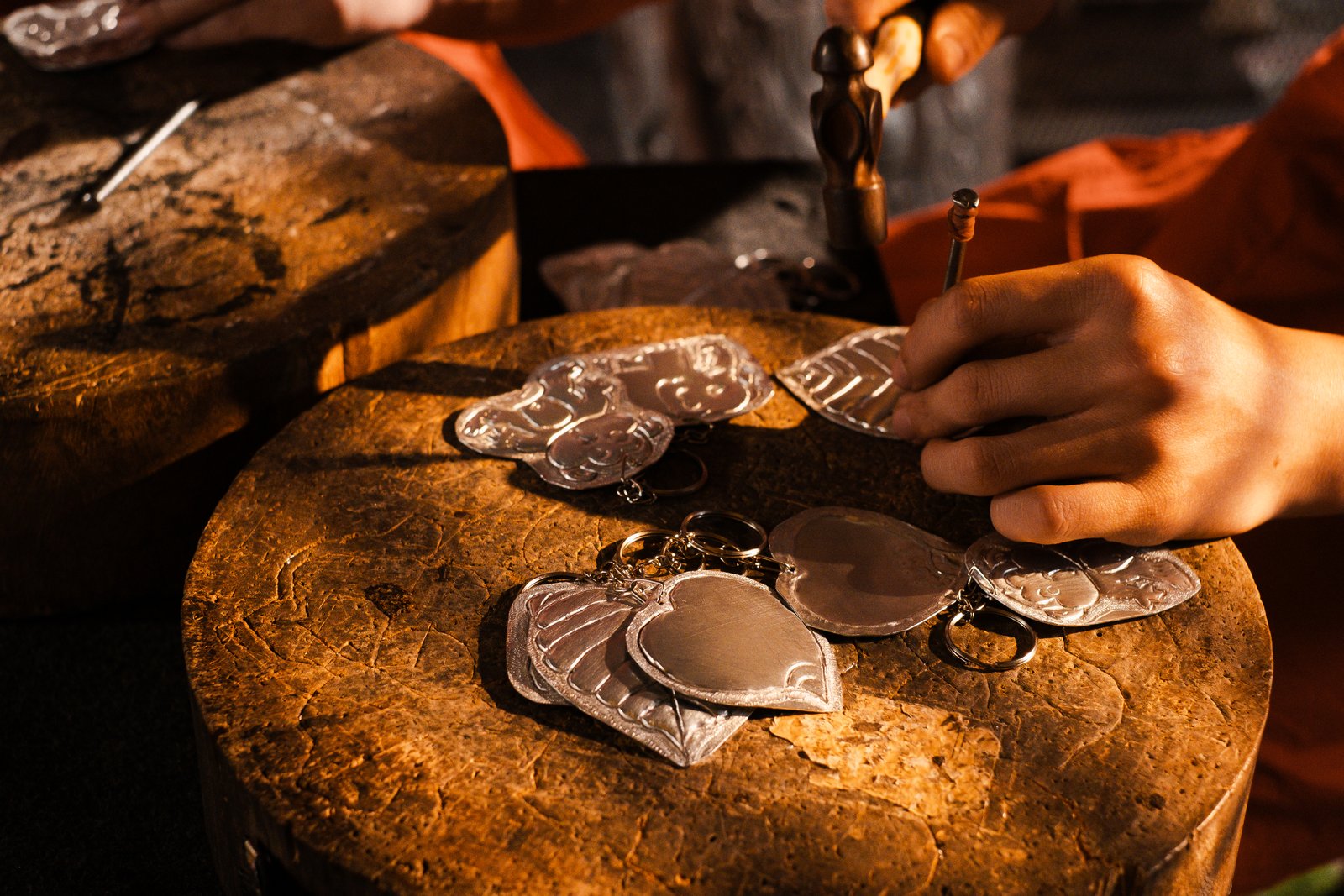 A silversmith hammering silver heart ornaments