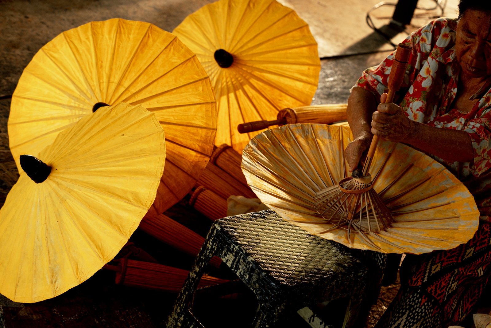 A maker working among golden yellow paper parasols