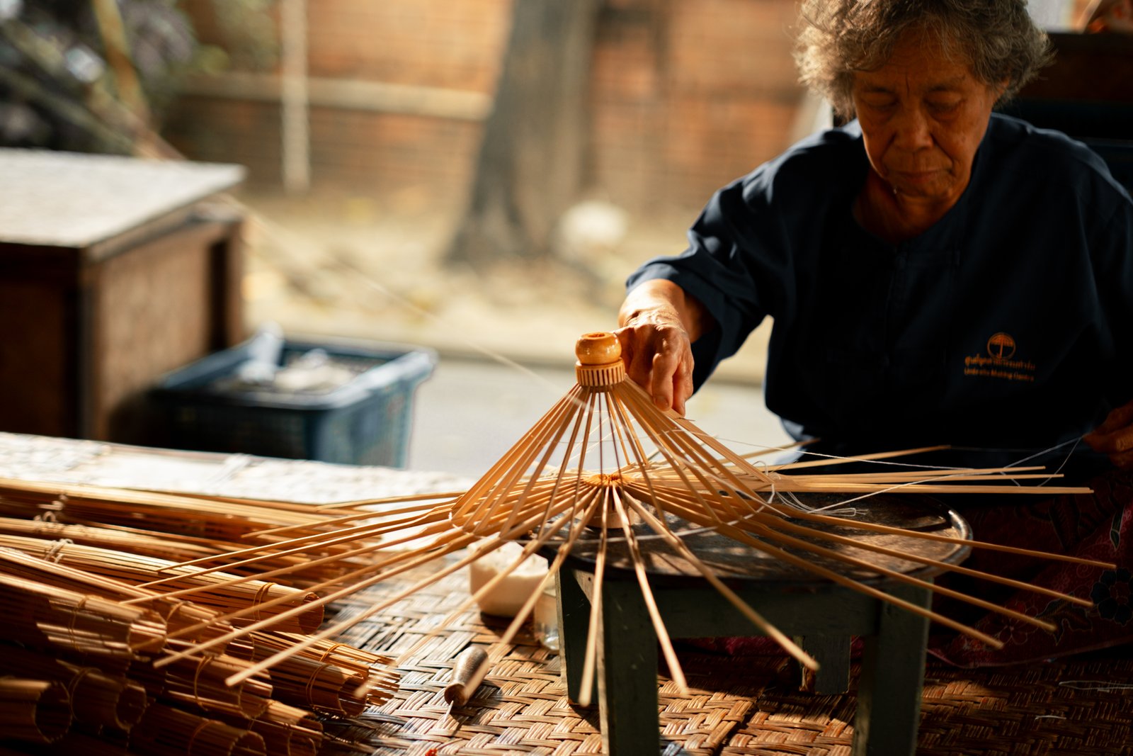 An elder assembling bamboo umbrella ribs
